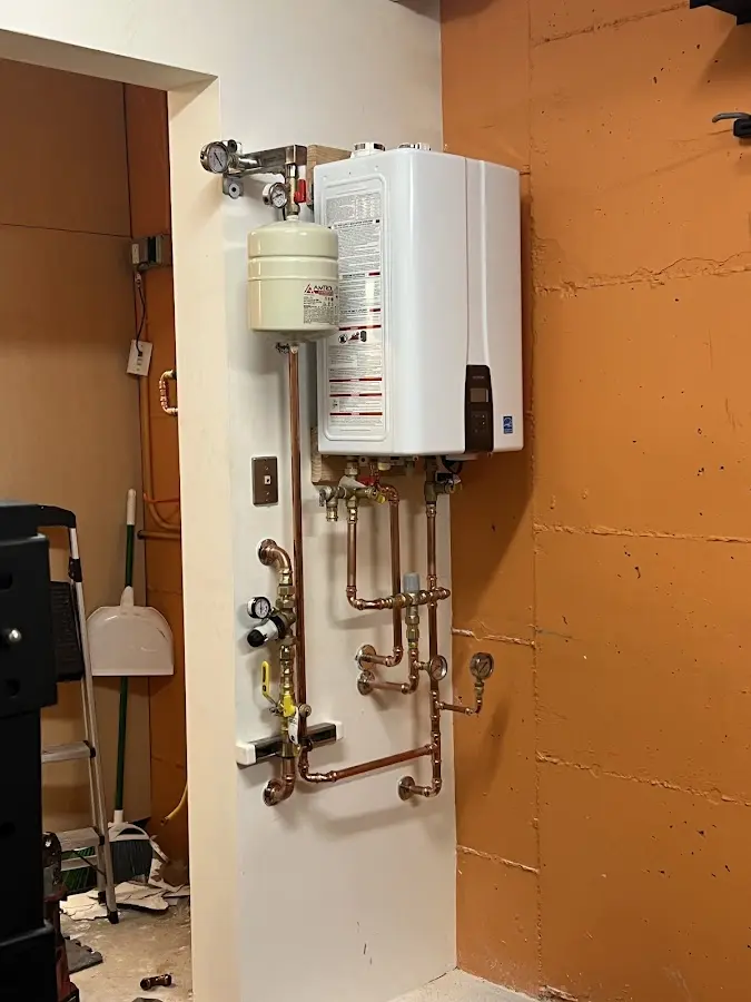 Plumbing technician inspecting water heater connections in Abington